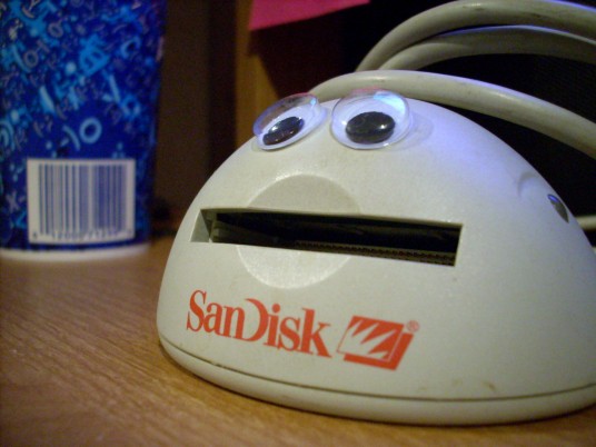 a sandisk card reader with googly eyes on it
